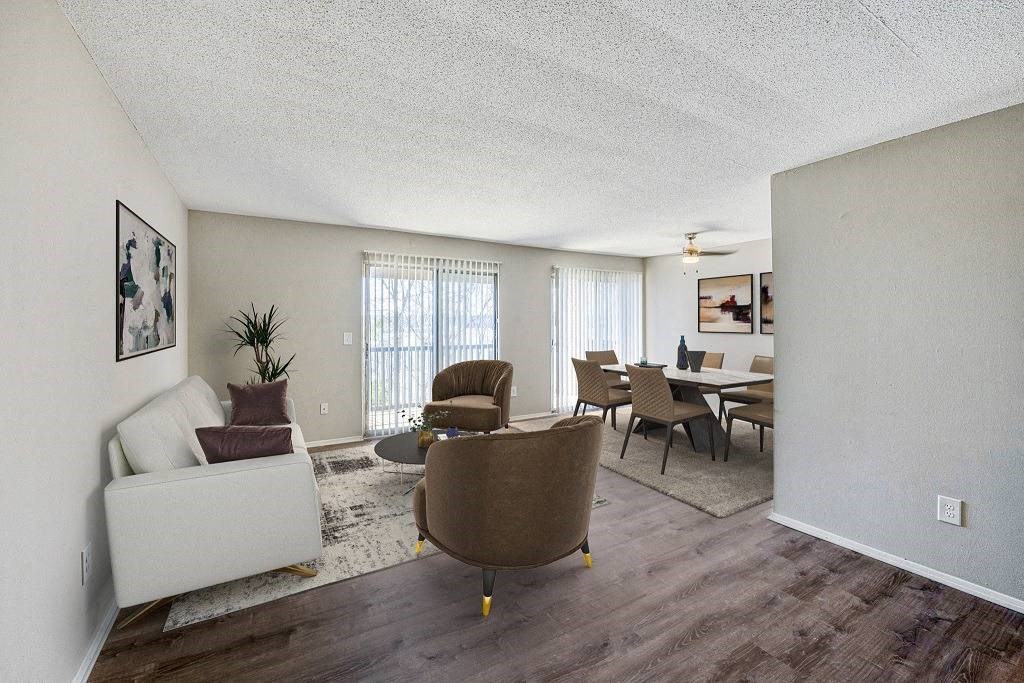 A living room with a brown chair and a white couch at The Waverly on the Lake - Belleville, MI Apartment, Belleville, MI, 48111