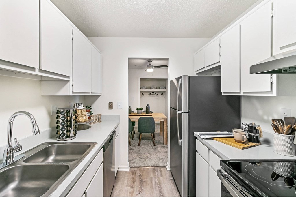 A kitchen with white cabinets and a black refrigerator at The Waverly on the Lake - Belleville, MI Apartment , Michigan