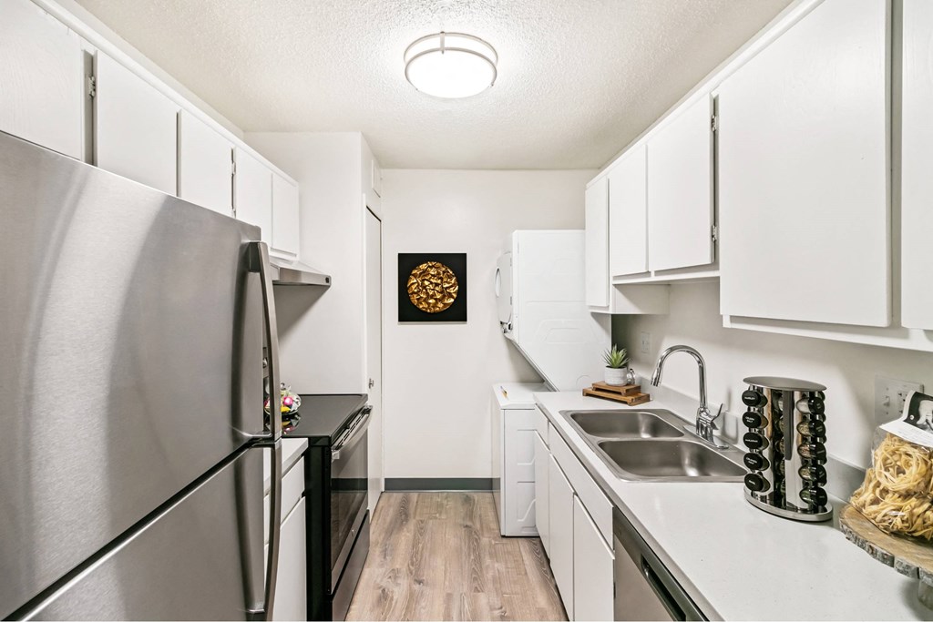 A kitchen with a stainless steel refrigerator and white cabinets at The Waverly on the Lake - Belleville, MI Apartment, Belleville, MI, 95050