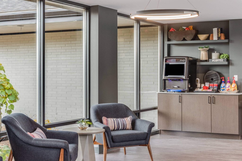 A modern living room with grey armchairs and a grey coffee table at The Waverly on the Lake - Belleville, MI Apartment , Michigan