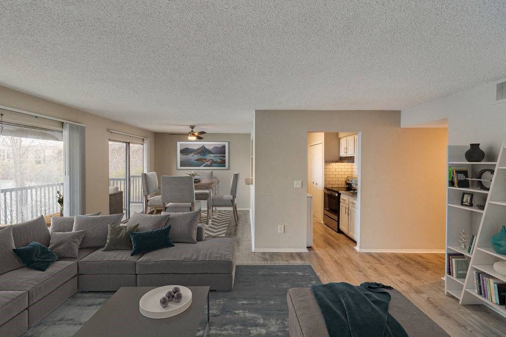 A living room with a grey couch and a coffee table at The Waverly on the Lake - Belleville, MI Apartment, Belleville, MI, 95050