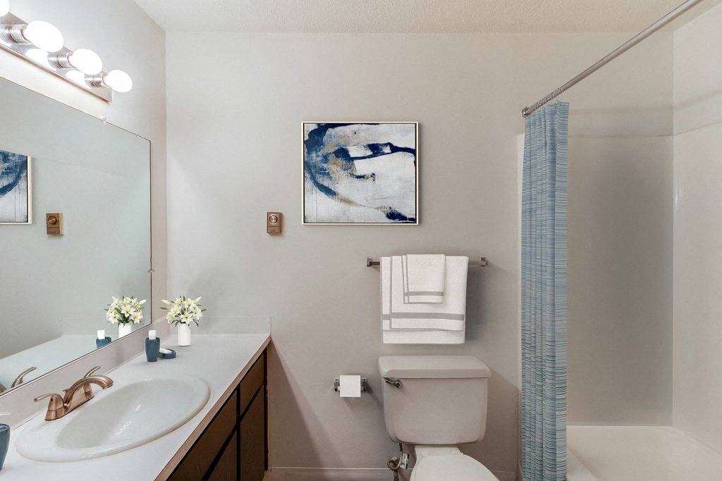A bathroom with a toilet, sink, and shower at The Waverly on the Lake - Belleville, MI Apartment , Belleville, MI