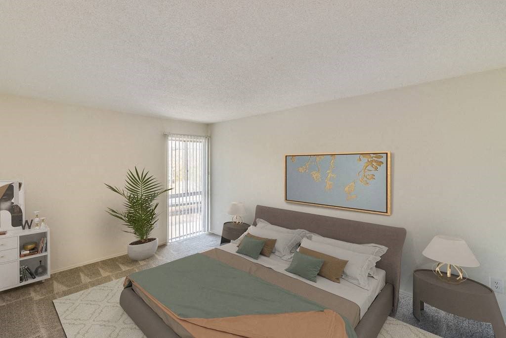 A bedroom with a bed, nightstand, and a plant at The Waverly on the Lake - Belleville, MI Apartment, Belleville, MI, 95050