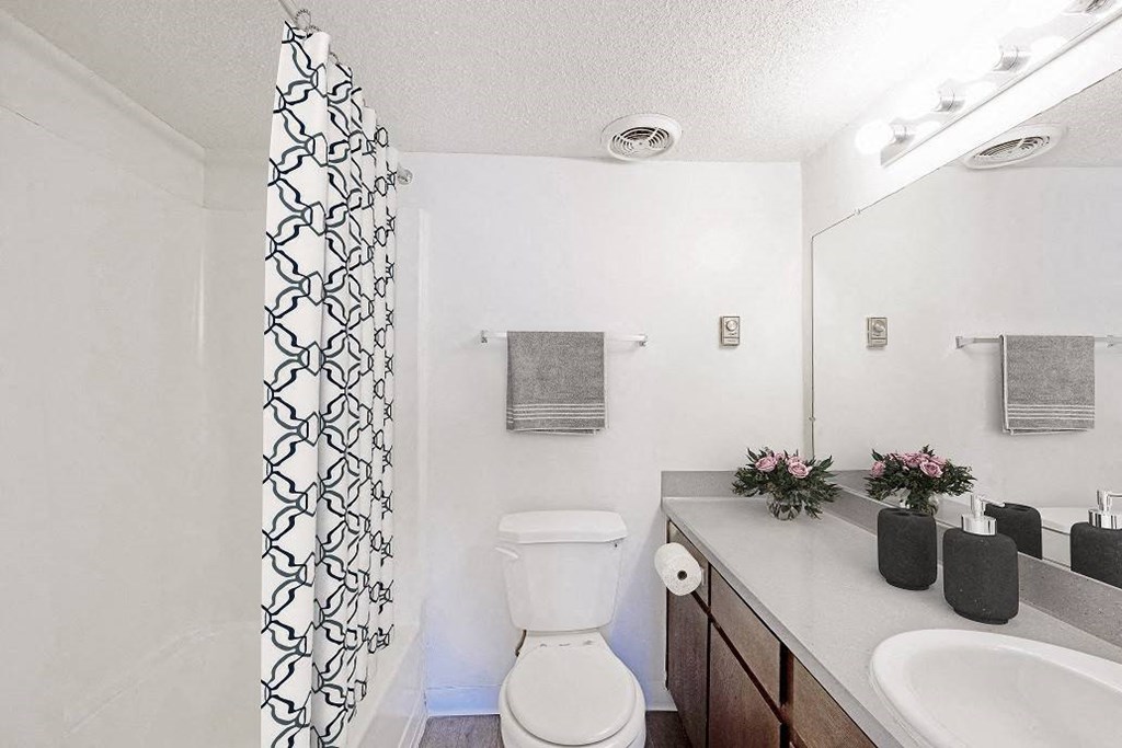 A white toilet sits in a bathroom next to a sink at The Waverly on the Lake - Belleville, MI Apartment , Belleville, MI