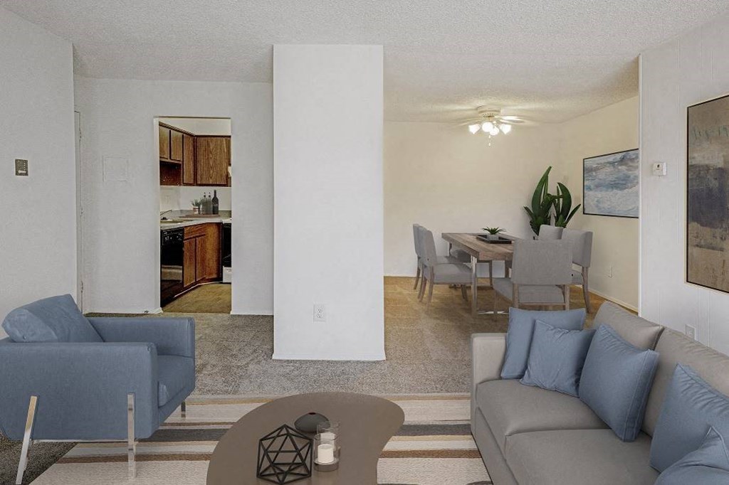 A living room with a grey couch and a blue chair at The Waverly on the Lake - Belleville, MI Apartment , Belleville, 95050