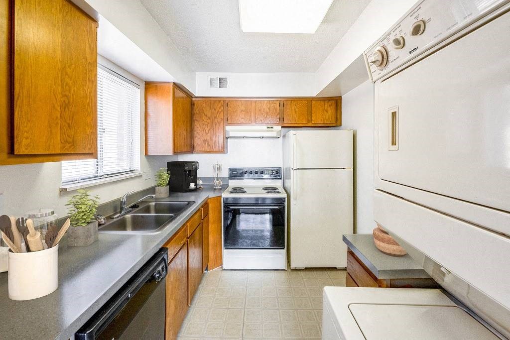 A kitchen with a white oven and black countertops at The Waverly on the Lake - Belleville, MI Apartment , Michigan, 95050