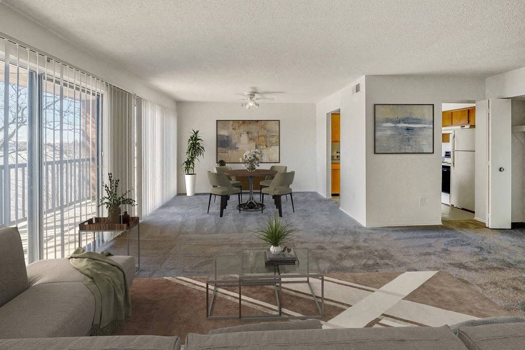 A living room with a couch, a coffee table, and a painting on the wall at The Waverly on the Lake - Belleville, MI Apartment , Michigan