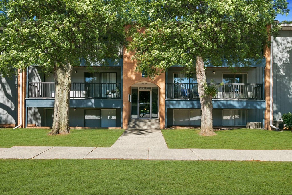 A building with a tree in front of it at The Waverly on the Lake - Belleville, MI Apartment , Belleville