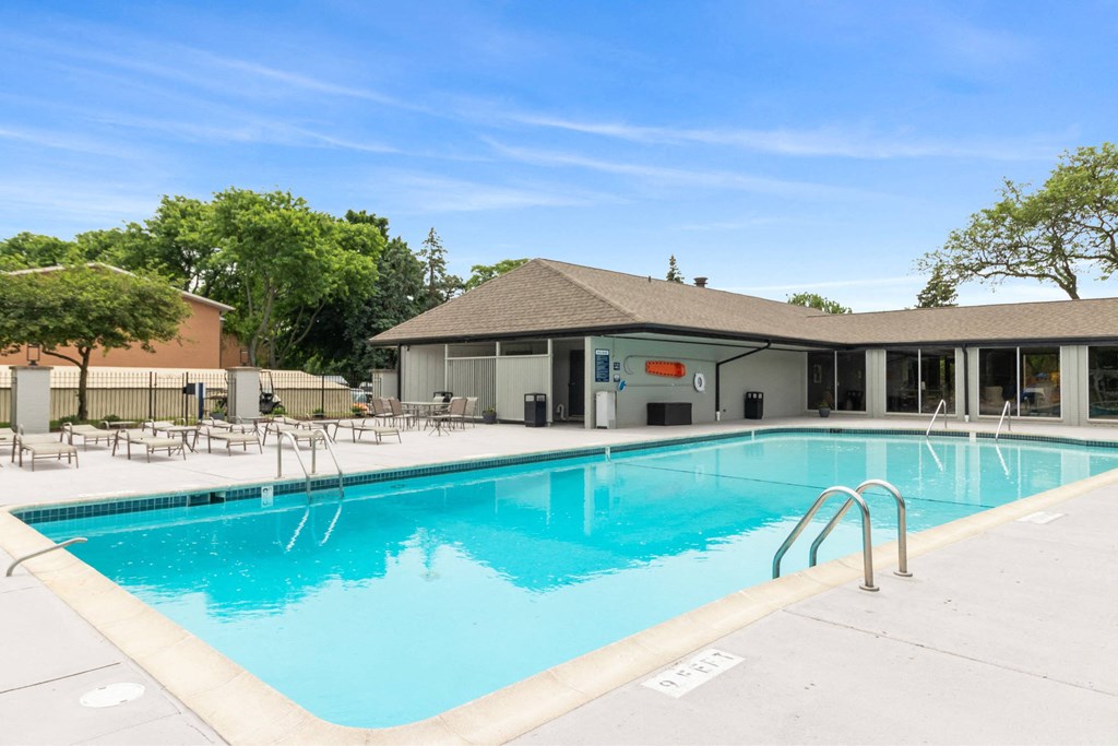 A large swimming pool with a building in the background. A large swimming pool with a building in the background at The Waverly on the Lake - Belleville, MI Apartment , Belleville, 95050