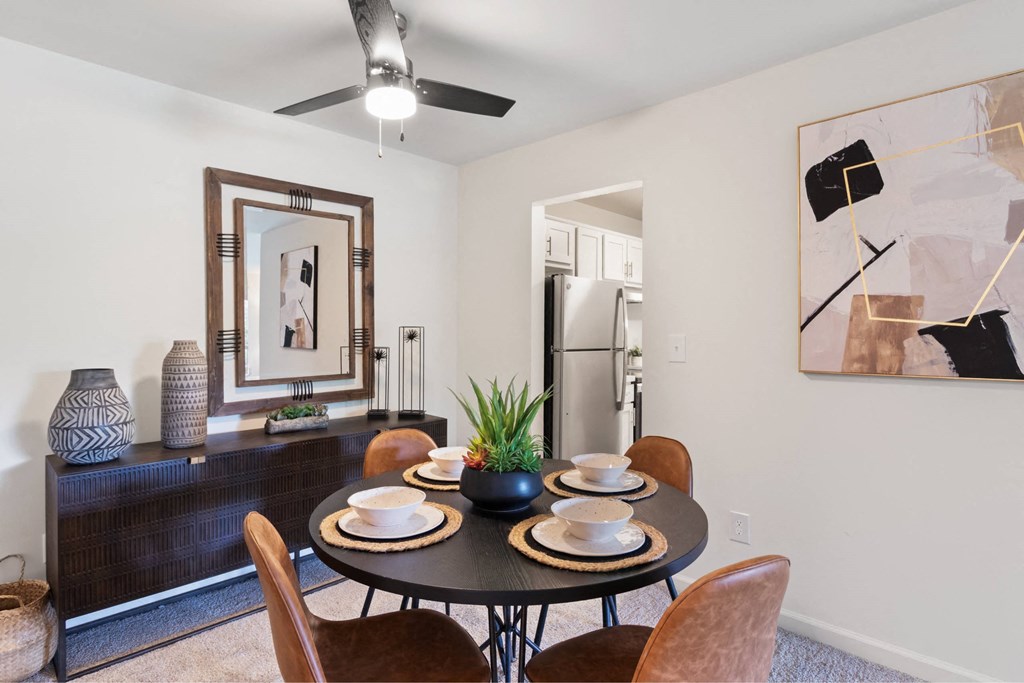 A dining room with a table set for two and a ceiling fan at The Waverly on the Lake - Belleville, MI Apartment , Belleville, MI