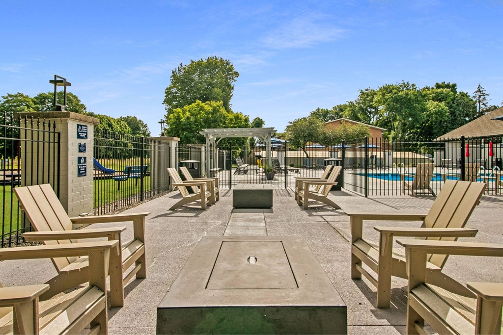 A sunny day at the park with wooden benches and a pool at The Waverly on the Lake - Belleville, MI Apartment , Michigan, 95050