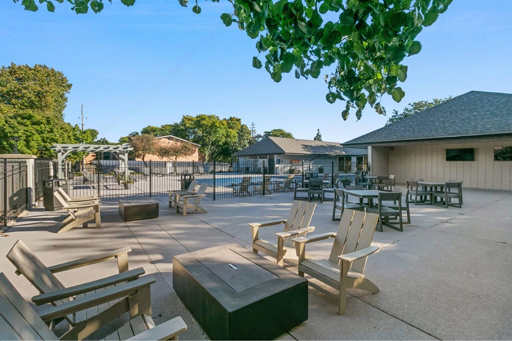 A sunny day at the park with wooden benches and picnic tables at The Waverly on the Lake - Belleville, MI Apartment , Belleville, 95050