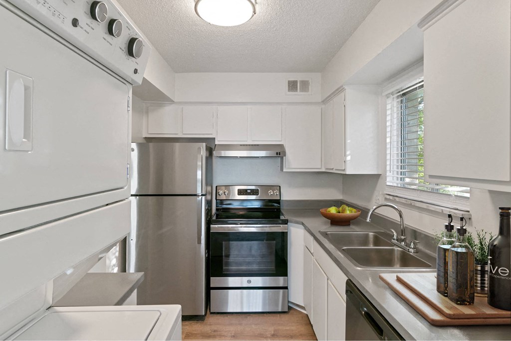 A modern kitchen with stainless steel appliances and white cabinets at The Waverly on the Lake - Belleville, MI Apartment , Belleville