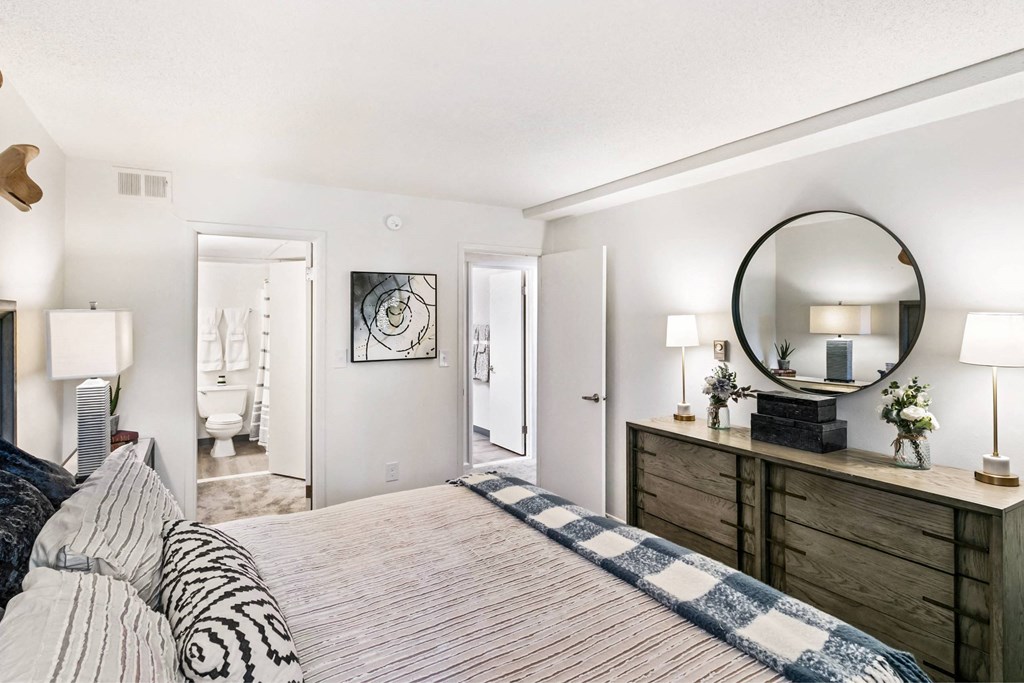 A bedroom with a bed, dresser, and mirror at The Waverly on the Lake - Belleville, MI Apartment , Belleville, MI