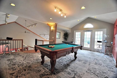A pool table in a room with a carpeted floor.