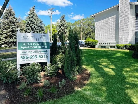 A sign for a renovated apartment home leasing office.