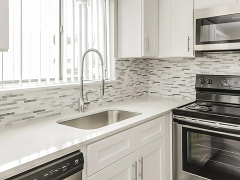 A modern kitchen with a stainless steel oven and a white countertop.