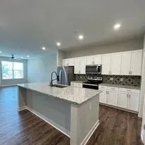 A kitchen with white cabinets and a countertop.