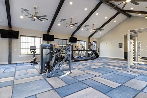 A spacious gym with a variety of equipment and a checkered floor.