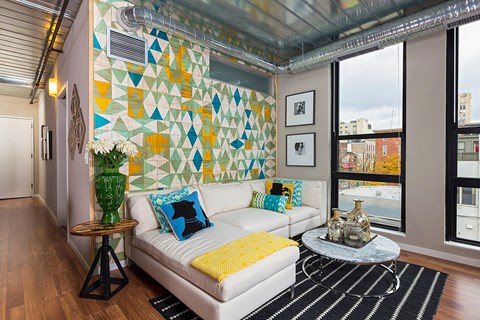 A living room with a white couch and a yellow throw pillow.