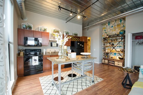 A kitchen with a black oven and a black fridge.
