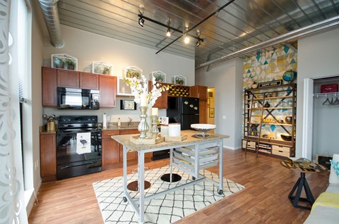 A kitchen with a black oven and a black fridge.