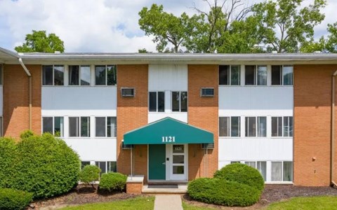 A building with a green awning and the number 1121 on it.