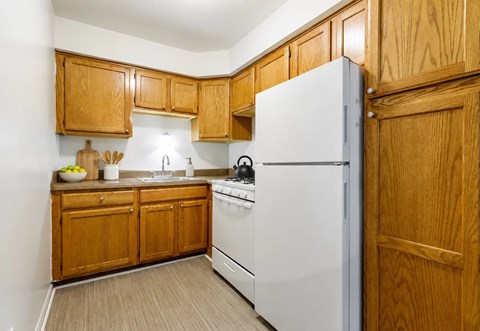 A kitchen with wooden cabinets and a white refrigerator.
