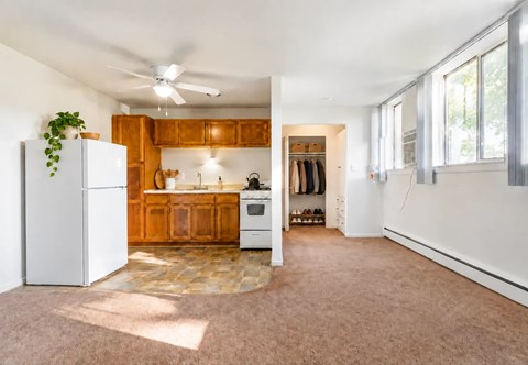 A kitchen with wooden cabinets and a white refrigerator.