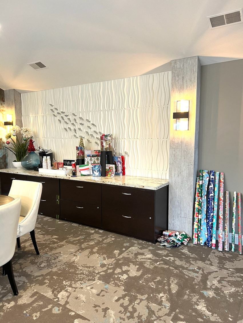 the living room of a hotel room with a counter and some clothes on the floor