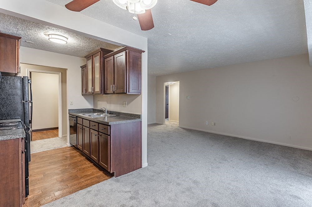 an empty kitchen and living room with wood flooring