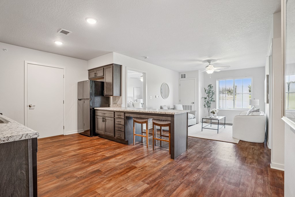 A kitchen with wooden floors and a marble counter.