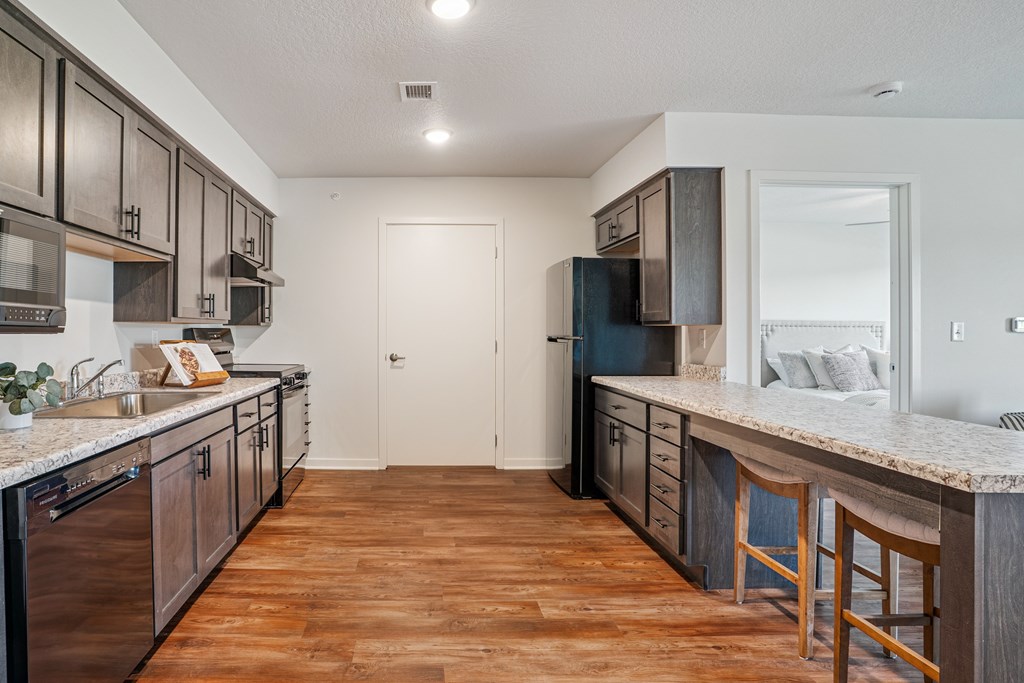 A kitchen with wooden floors and a white counter top.