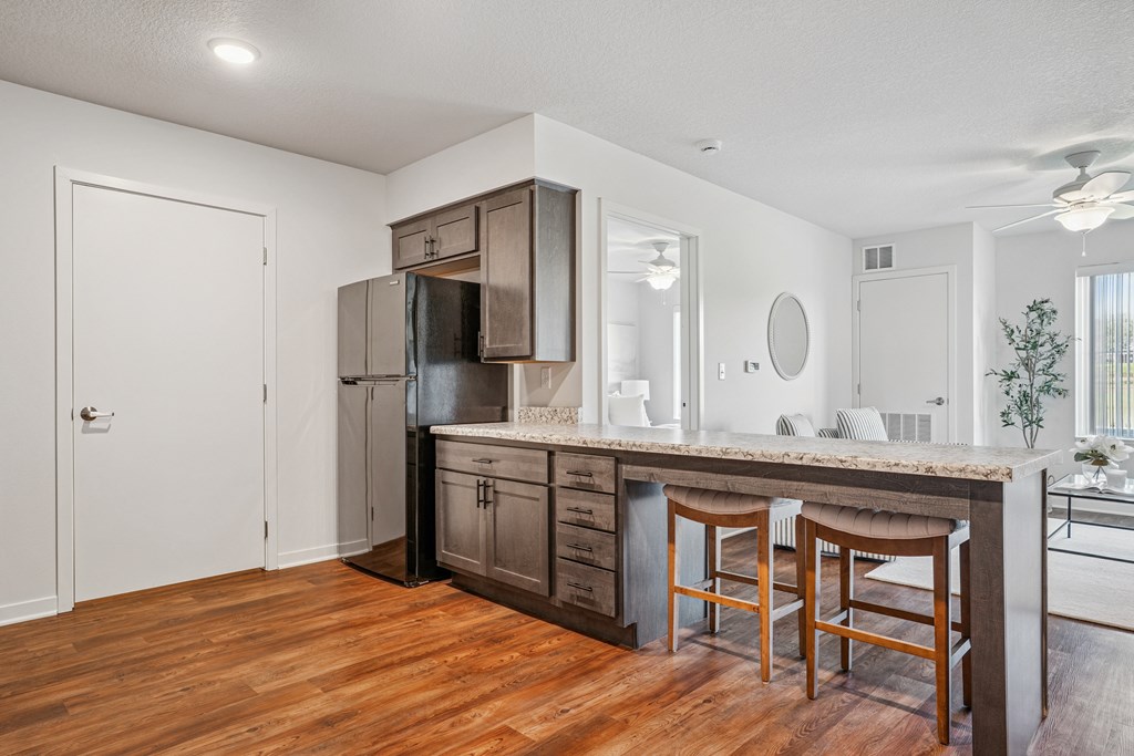 A kitchen with wooden floors and a white ceiling.