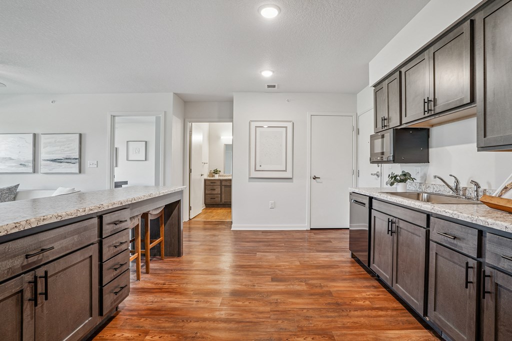A kitchen with dark wood cabinets and a white counter top.