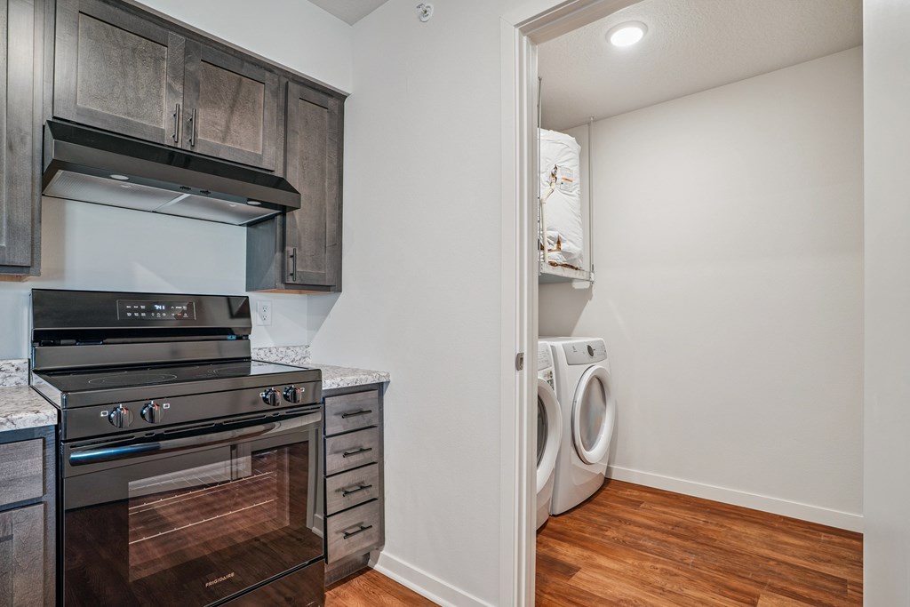 A kitchen with a stove top oven and a washing machine.