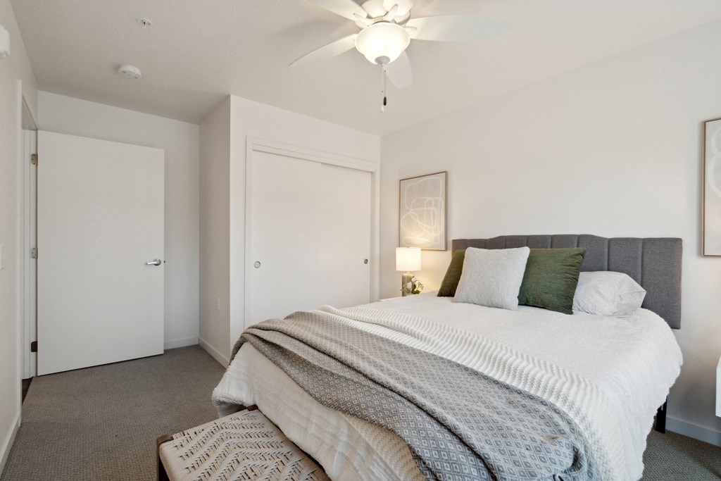 a bedroom with a large bed and a ceiling fan