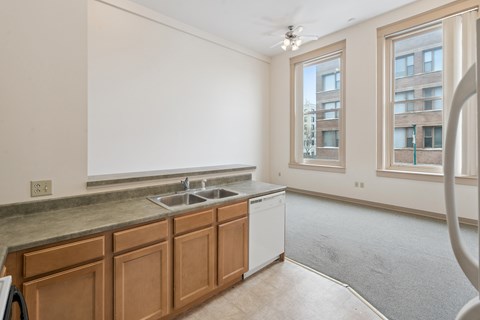 A kitchen with wooden cabinets and a window.