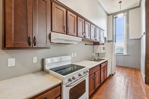 A kitchen with wooden cabinets and a white stove top oven.