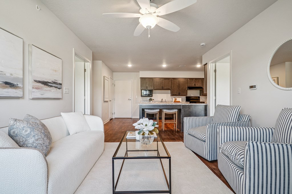 A living room with a white couch and a striped armchair.