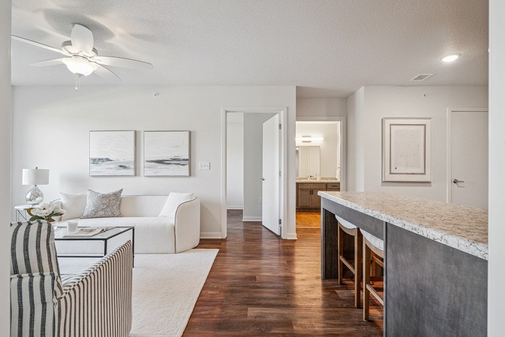 A living room with a striped chair and a white couch.