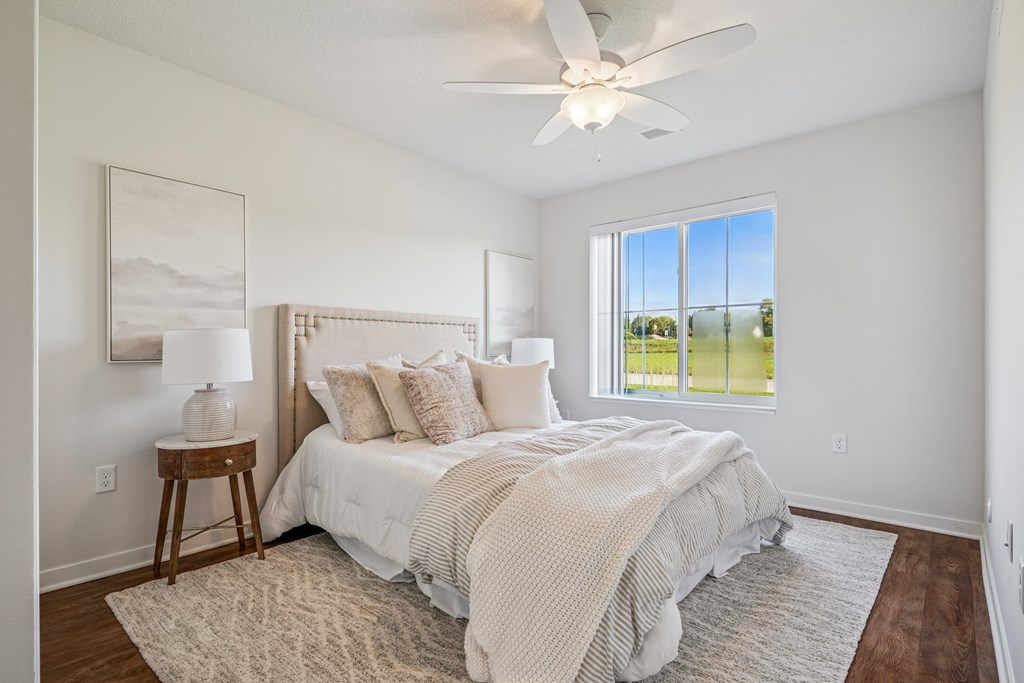 A bedroom with a large bed and a ceiling fan.