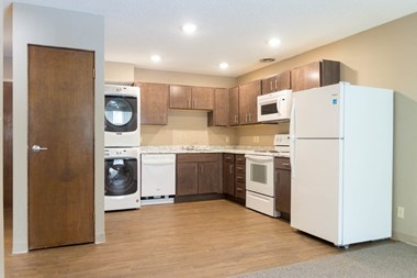 a kitchen with brown cabinets and white appliances