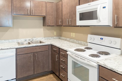 a kitchen with white appliances and brown cabinets