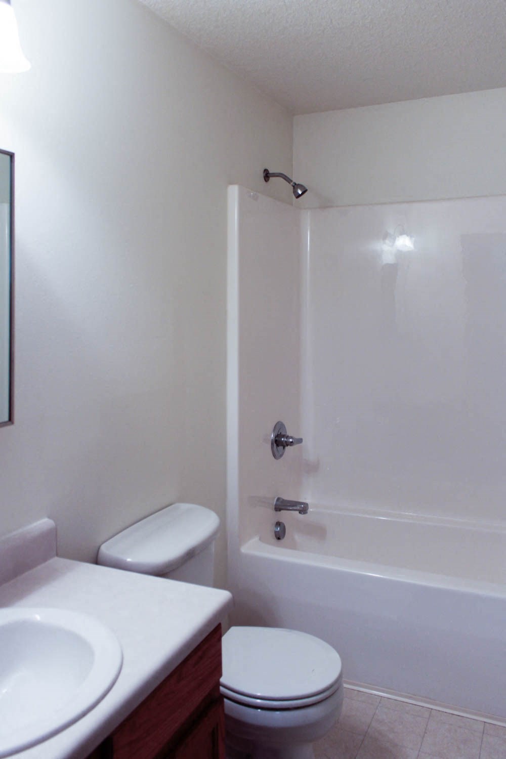 A white toilet sits next to a white sink in a small bathroom.