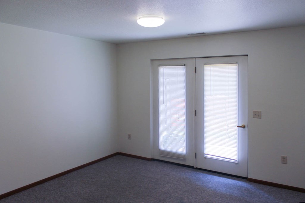 A room with a carpeted floor and a sliding door.