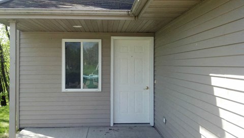 A small house with a white door and window.
