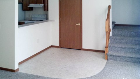 A brown door is in a white hallway.