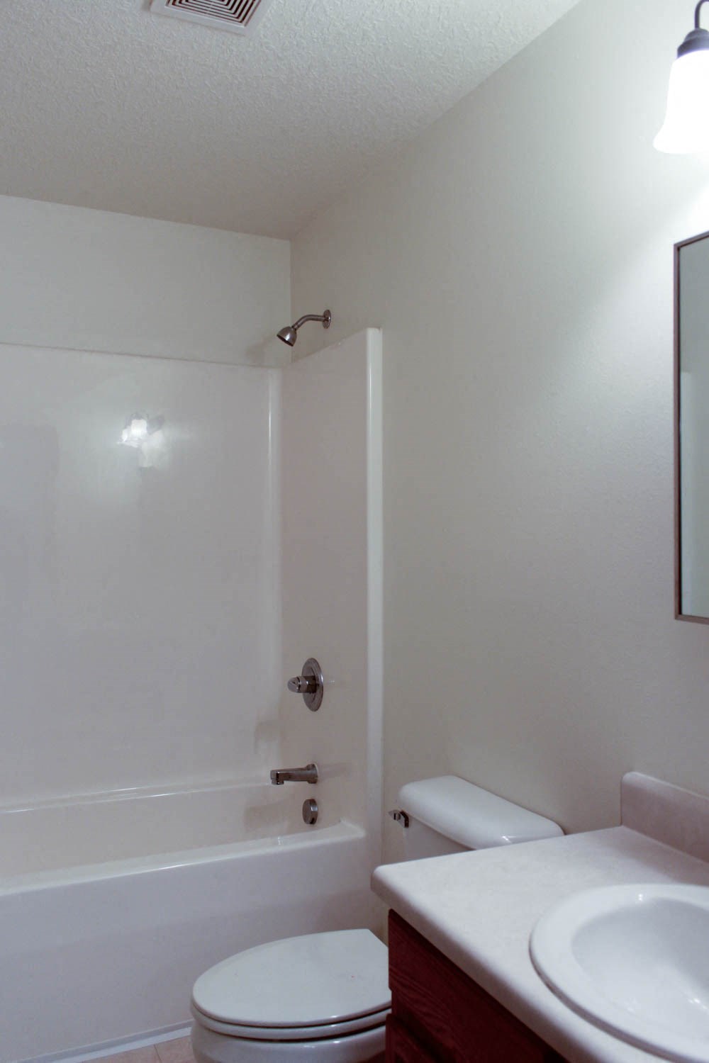 A white toilet sits next to a white sink in a small bathroom.