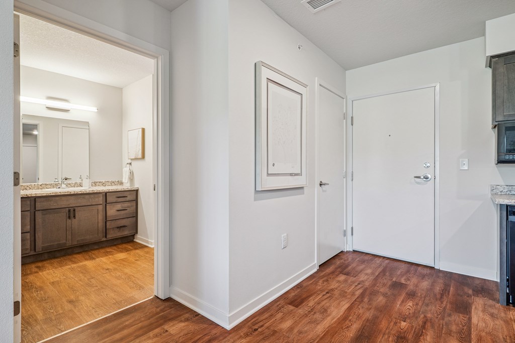 A bathroom with a wooden floor and white walls.